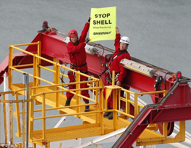 True believer: Lucy Lawless waves a placard aboard the drilling ship Noble Discoverer in an attempt to stop it from sailing to Alaska